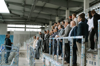 Menschen in Business Kleidung stehen auf der Stadiontribüne